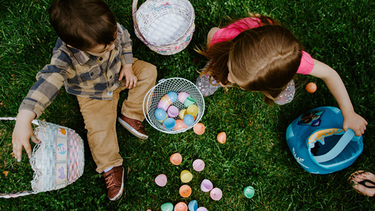 Two children collect colorful eggs