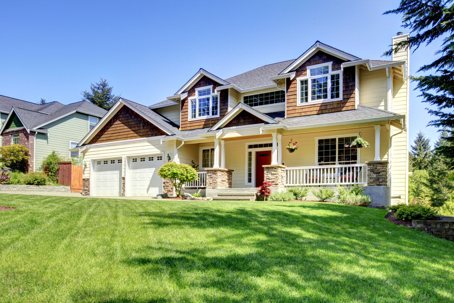 a picture of a home with a sprawling lawn and a two-car garage.