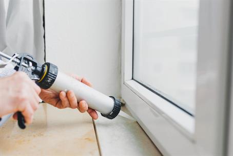 Caulking around a window frame.