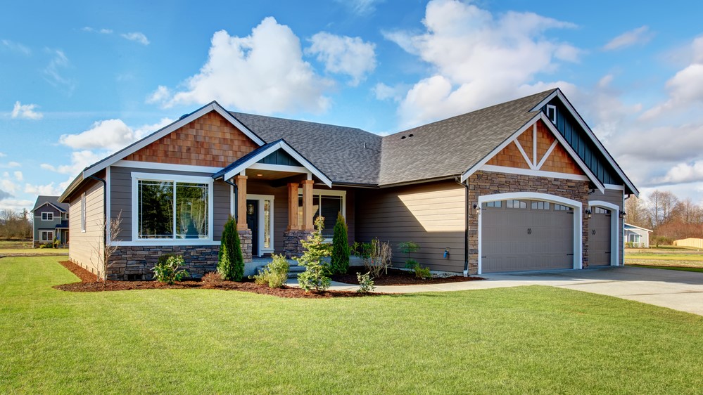 large modern home with stonework and green front yard