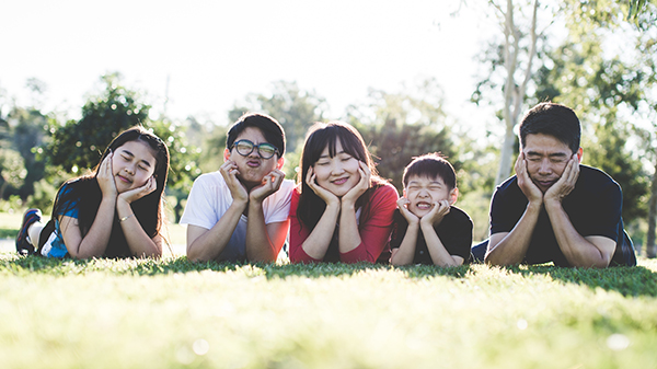 family smiling on ground outside